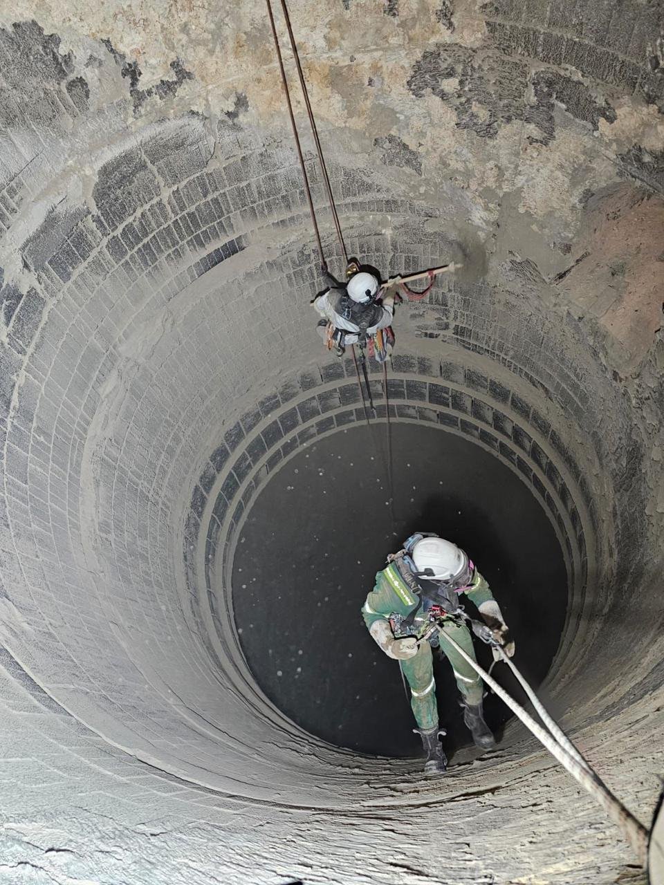 Alpinista industrial descendo em silo